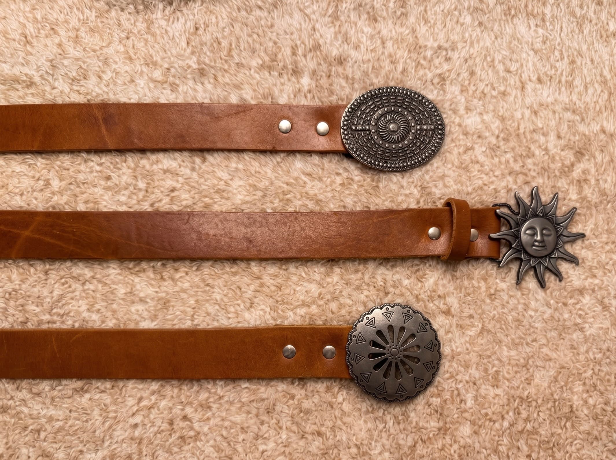 Cintos de cuero marrón con diferentes hebillas metálicas personalizadas