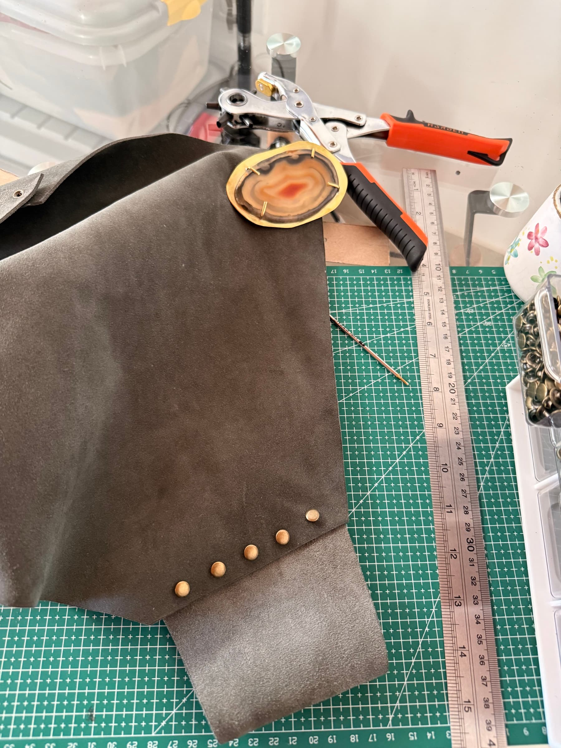 Pieza de cuero personalizada junto a herramientas y herrajes del taller