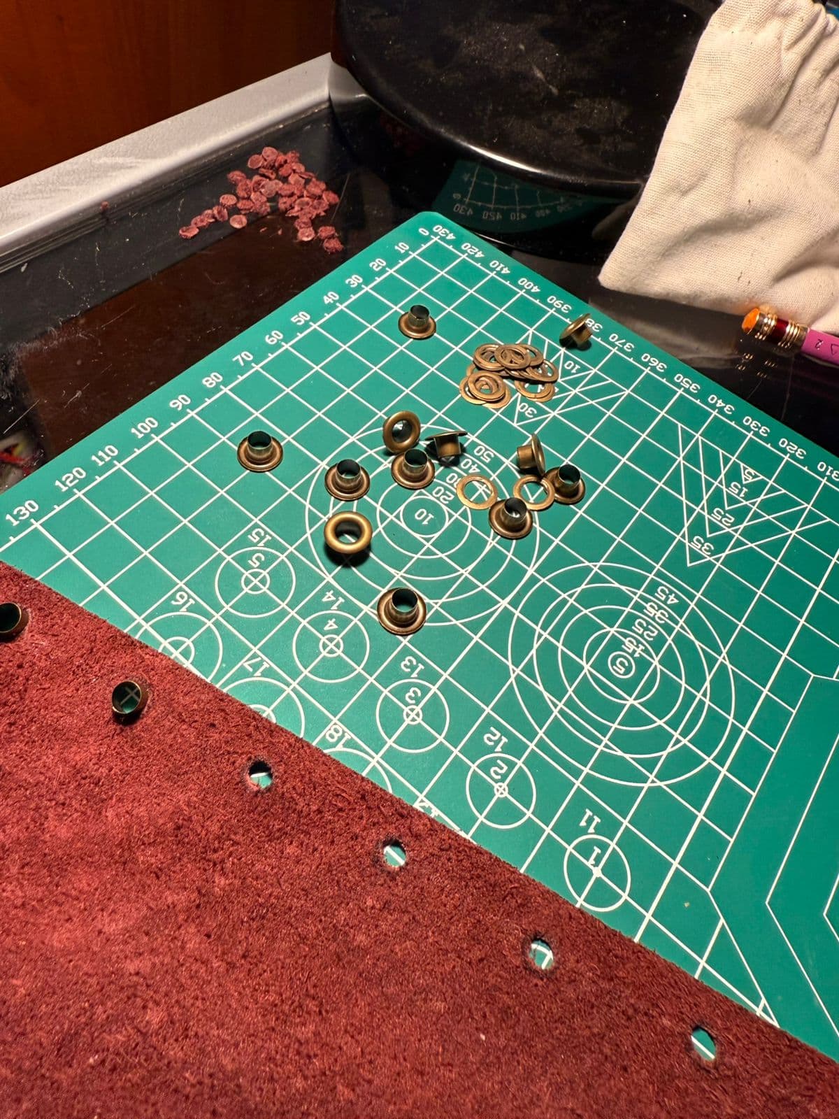 Cuero y remaches preparados sobre una mesa de trabajo